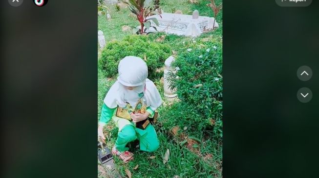 Bikin Mata Berkaca-kaca! Viral Bocah Susun Piala yang Ia Dapatkan di Makam Sang Ayah Sambil Berdoa. (Dok: TIkTok/ustazahnurul.k_k)