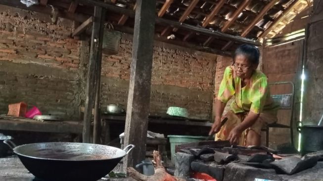 Mbah Tumi asal Gunungkidul sedang membuat minyak goreng buatan sendiri berasal dari olahan blondo yang diproses dari buah kelapa. [Kontributor / Julianto]