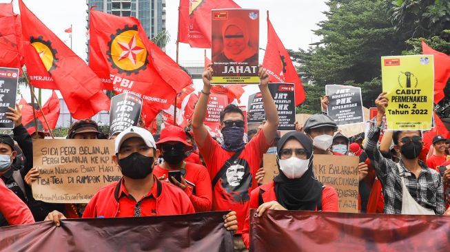 Massa buruh saat menggelar aksi unjuk rasa di depan gedung Kementerian Tenaga Kerja (Kemenaker) di Setia Budi, Jakarta Selatan, Rabu (23/2/2022). [Suara.com/Alfian Winanto]