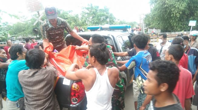 Warga mengevakuasi korban kecelakaan mobil Daihatsu Xenia dengan KA Bangunkarta di perlintasan Sumpiuh, Kabupaten Banyumas, Rabu (23/2/2022) siang. [Dokumentasi DAOP 5 Purwokerto]