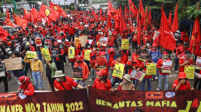 Massa buruh saat menggelar aksi unjuk rasa di depan gedung Kementerian Tenaga Kerja (Kemenaker) di Setia Budi, Jakarta Selatan, Rabu (23/2/2022). [Suara.com/Alfian Winanto]