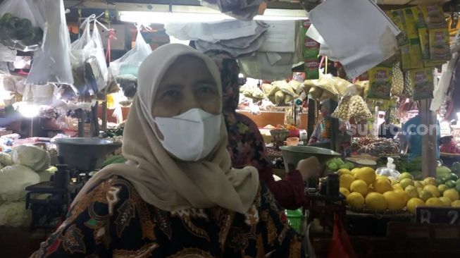 Ida Rahayu (54) penjual bahan pangan di Pasar Tomang Barat, Jakarta Barat, Rabu (23/2/2022). [Suara.com/Faqih Fathurrahman]