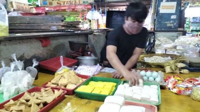 Pipit, pedagang tahu sedang menjajakan barang dagangannya di Pasar Slipi, Palmerah, Jakarta Barat, Kamis (24/2/2022). [ANTARA/Walda]