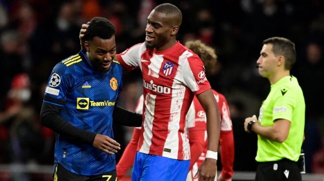 Penyerang Manchester United, Anthony Elanga (kiri) bercengkerama dengan gelandang Atletico Madrid, Geoffrey Kondogbia usai laga 16 besar Liga Champions di Estadio Wanda Metropolitano, Madrid, Spanyol, Kamis (24/2/2022) dini hari WIB. [JAVIER SORIANO / AFP]