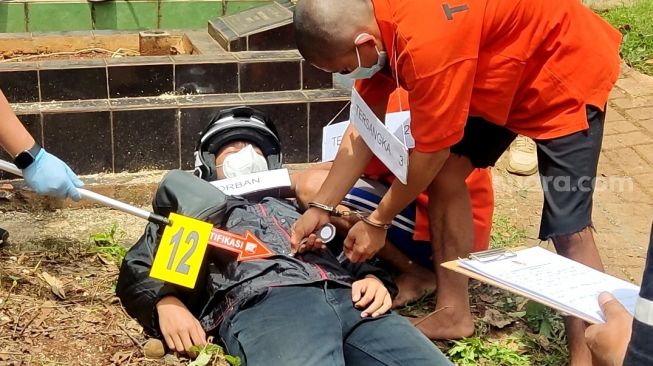 Rekonstruksi kasus pembunuhan Ficky Firlana alias Abun di Pemakaman Chober, Pesanggrahan, Jaksel. (Suara.com/Yaumal)