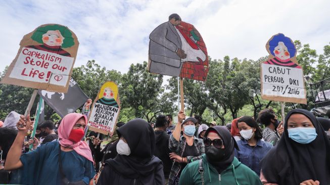 Massa yang tergabung dalam Koalisi Rakyat Menolak Penggusuran (KRMP) menggelar aksi di depan Balai Kota DKI Jakarta, Jakarta Pusat, Kamis (24/2/2022). [Suara.com/Alfian Winanto]