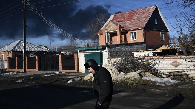 Asap hitam mengepul dari bandara militer di Chuguyev dekat Kharkiv pada 24 Februari 2022. 
Aris Messinis / AFP
