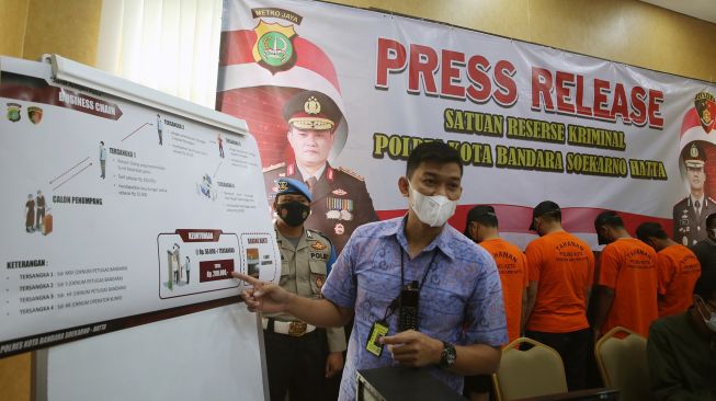 Kasat Reskrim Polres Bandara Soekarno Hatta Kompol Rezha Rahandhi menunjukan alur kejahatan pemalsuan surat hasil tes PCR dan antigen untuk syarat naik pesawat di Mapolresta Bandara Soekarno Hatta, Tangerang, Banten, Jumat (25/2/2022). ANTARA FOTO/Muhammad Iqbal