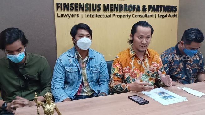 Para Korban Binomo Indra Kenz: P (baju hijau), R (jaket biru) dan pengacara Finsensius Mendrofa (batik kuning) ditemui di kawasan Kuningan, Jakarta Selatan pada Jumat (25/2/2022). [Rena Pangesti/Suara.com]