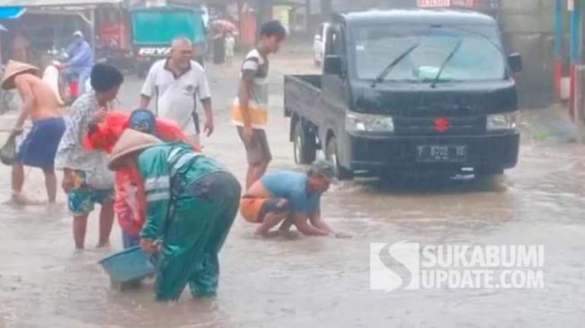 Sambil Hujan-hujanan, Warga Sukabumi Panen Ikan di Ruas Jalan Provinsi Surade-Ujunggenteng