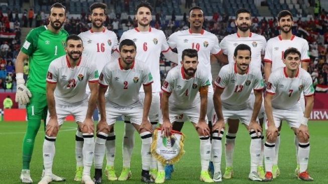 Para pemain Timnas Yordania berpose untuk foto bersama menjelang pertandingan sepak bola perempat final Piala Arab FIFA 2021 antara Mesir dan Yordania di Stadion Al-Janoub di kota Al-Wakrah, Qatar, pada 11 Desember 2021. KARIM JAAFAR/AFP