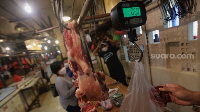 Penjual daging sapi melayani pembeli di salah satu los daging di Pasar Senen, Jakarta, Sabtu (26/2/2022). [Suara.com/Angga Budhiyanto]