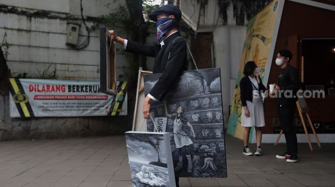 Seniman melakukan aksi pameran seni jalanan atau 'street art' di kawasan Dukuh Atas, Jakarta, Sabtu (26/2/2022). [Suara.com/Angga Budhiyanto]