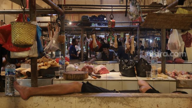 Penjual daging sapi membersihkan los daging di Pasar Senen, Jakarta, Sabtu (26/2/2022). [Suara.com/Angga Budhiyanto]