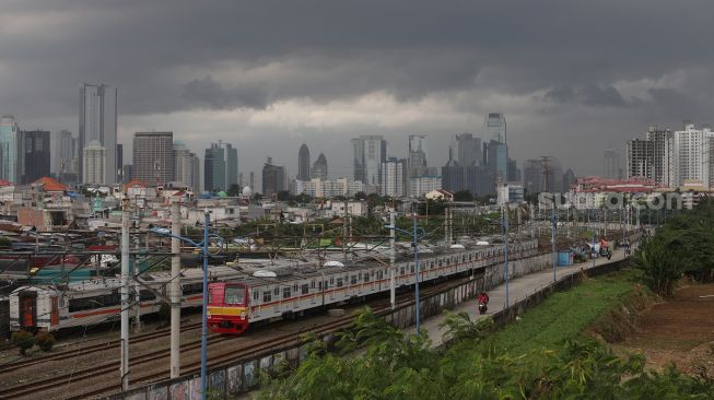 Rangkaian KRL Commuter Line melintas di dekat permukiman padat penduduk di kawasan Tanah Abang, Jakarta, Sabtu (26/2/2022). [Suara.com/Angga Budhiyanto]