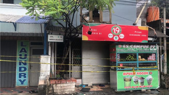 Garis polisi yang melintang di depan pintu kaca, akses utama rumah yang terbakar di Jalan Taman Radio Dalam 7, Kebayoran Lama, Jakarta Selatan, Sabtu (26/2/2022). [Suara.com/Faqih Fathurrahman]