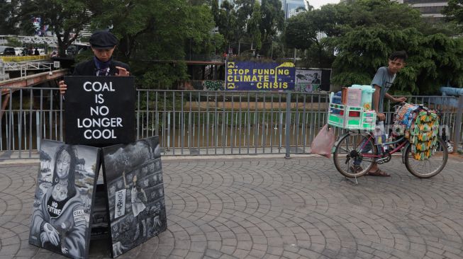 Seniman melakukan aksi pameran seni jalanan atau 'street art' di kawasan Dukuh Atas, Jakarta, Sabtu (26/2/2022). [Suara.com/Angga Budhiyanto]