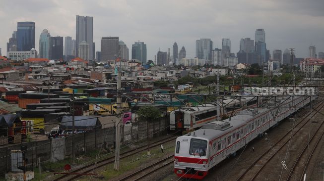 Rangkaian KRL Commuter Line melintas di dekat permukiman padat penduduk di kawasan Tanah Abang, Jakarta, Sabtu (26/2/2022). [Suara.com/Angga Budhiyanto]