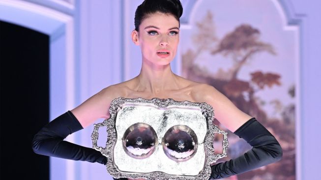 Seorang model menampilkan busana kreasi brand Moschino untuk koleksi Musim Gugur/Musim Dingin 2022/2023 di hari ketiga Milan Fashion Week di Milan, Italia, Kamis (24/2/2022). [MIGUEL MEDINA / AFP]
