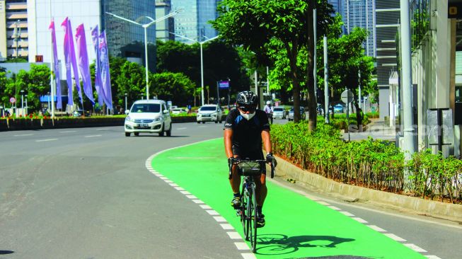 Warga bersepedah di kawasan jalan Jendral Sudirman, Jakarta, Minggu (27/2/2022). [Suara.com/Septian]