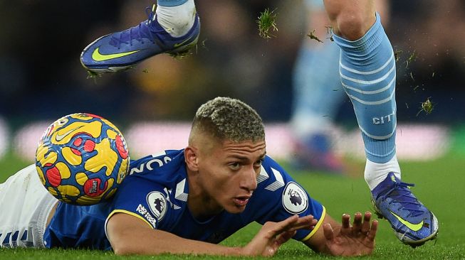 Striker Everton Richarlison bereaksi setelah dilanggar oleh bek Manchester City Ruben Dias saat pertandingan sepak bola Liga Premier Inggris antara Everton dan Manchester City di Stadion Goodison Park, Inggris, Sabtu (26/2/2022). [Oli SCARFF / AFP]