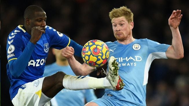 Gelandang Everton Abdoulaye Doucoure (kiri) bersaing dengan gelandang Manchester City Kevin De Bruyne (kanan) saat pertandingan sepak bola Liga Premier Inggris antara Everton dan Manchester City di Stadion Goodison Park, Inggris, Sabtu (26/2/2022). [Oli SCARFF / AFP]