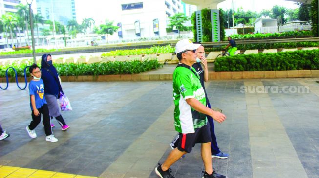 Warga berolahraga di kawasan jalan Jendral Sudirman, Jakarta, Minggu (27/2/2022). [Suara.com/Septian]