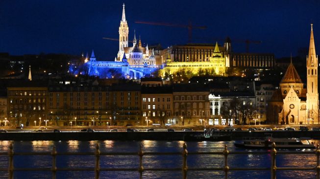 Benteng Nelayan diterangi dengan warna nasional Ukraina di Budapest, Hongaria, Jumat (25/2/2022). [ATTILA KISBENEDEK / AFP]