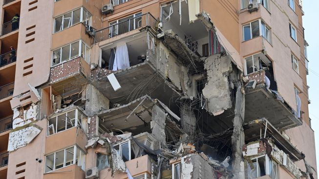 Pemandangan blok apartemen bertingkat tinggi yang terkena rudal serangan militer Rusia di Kyiv, Ukraina, Sabtu (26/2/2022). [GENYA SAVILOV / AFP]