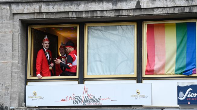 Orang-orang bersuka ria saat menghadiri acara musim Karnaval di Cologne, Jerman barat, Kamis (24/2/2022). [Ina Fassbender / AFP]