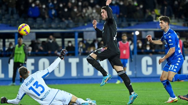 Penyerang Juventus Dusan Vlahovic (tengah) menendang dan mencetak gol ketiga timnya saat pertandingan sepak bola Serie A Italia antara Empoli dan Juventus di stadion Carlo-Castellani di Empoli, Italia, Sabtu (26/2/2022). [Alberto PIZZOLI / AFP]