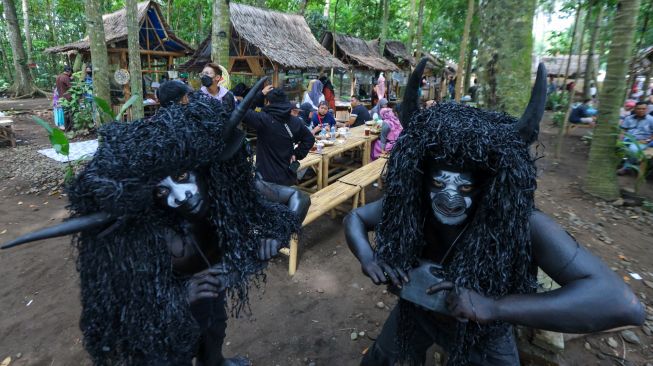 Tradisi adat kebo-keboan berpose di pasar witwitan Alas Malang, Singojuruh, Banyuwangi, Jawa Timur, Minggu (27/2/2022). [ANTARA FOTO/Budi Candra Setya/aww]