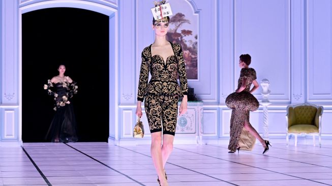 Seorang model menampilkan busana kreasi brand Moschino untuk koleksi Musim Gugur/Musim Dingin 2022/2023 di hari ketiga Milan Fashion Week di Milan, Italia, Kamis (24/2/2022). [MIGUEL MEDINA / AFP]
