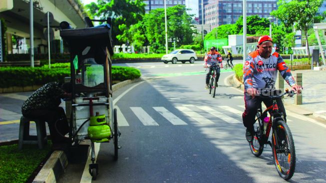 Warga bersepeda di kawasan jalan Jendral Sudirman, Jakarta, Minggu (27/2/2022). [Suara.com/Septian]