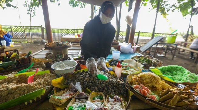 Pedagang berjualan jajanan tradisional di pasar witwitan Alas Malang, Singojuruh, Banyuwangi, Jawa Timur, Minggu (27/2/2022). [ANTARA FOTO/Budi Candra Setya/aww]