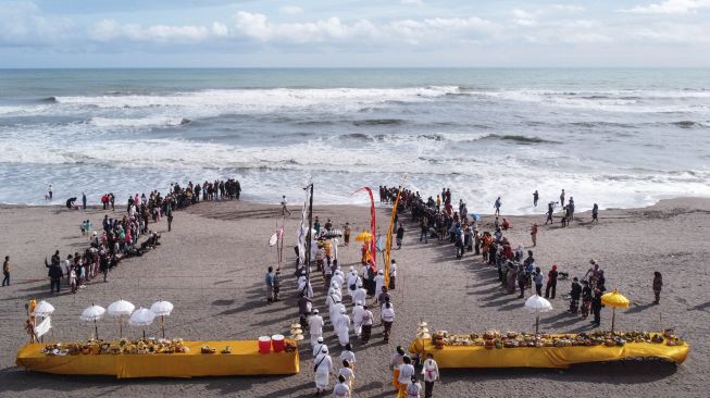 Sejumlah pemuka umat Hindu berjalan mengambil air suci saat upacara Melasti di Pantai Parangkusumo, Kretek, Bantul, DI Yogyakarta, Minggu (27/2/2022). [ANTARA FOTO/Hendra Nurdiyansyah/YU]