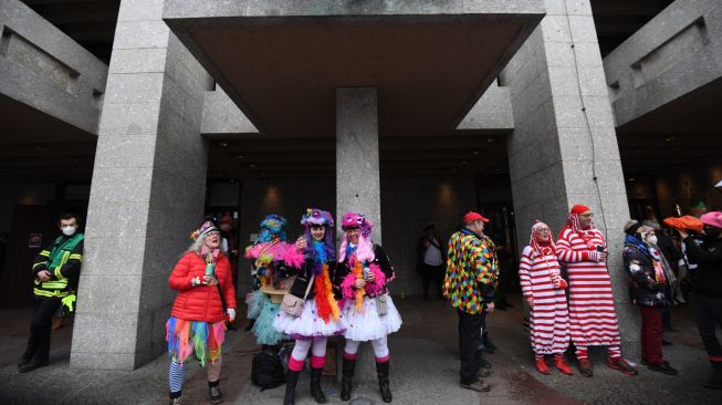 Orang-orang saat menghadiri acara musim Karnaval di Cologne, Jerman barat, Kamis (24/2/2022). [Ina Fassbender / AFP]