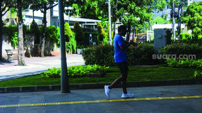 Warga berolahraga di kawasan jalan Jendral Sudirman, Jakarta, Minggu (27/2/2022). [Suara.com/Septian]