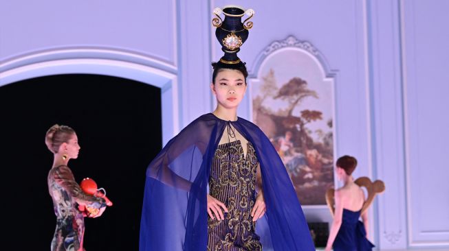 Seorang model menampilkan busana kreasi brand Moschino untuk koleksi Musim Gugur/Musim Dingin 2022/2023 di hari ketiga Milan Fashion Week di Milan, Italia, Kamis (24/2/2022). [MIGUEL MEDINA / AFP]
