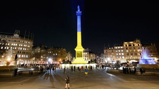  Warna bendera Ukraina diproyeksikan ke Nelson's Column di Trafalgar Square, London, Inggris, Jumat (25/2/2022). [Tolga Akmen / AFP]