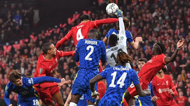 Penjaga gawang Chelsea Edouard Mendy meninju bola saat pertandingan sepak bola final Piala Liga Inggris / Carabao antara Chelsea dan Liverpool di Stadion Wembley, Inggris, Minggu (27/2/2022). [JUSTIN TALLIS / AFP]