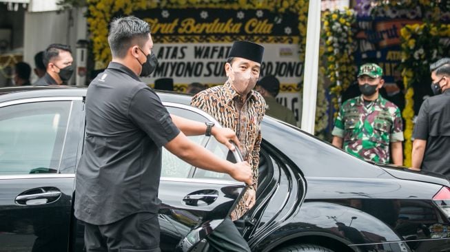 Presiden Joko Widodo turun dari mobil saat tiba di rumah duka kediaman almarhum Miyono Suryasardjono di Kampung Gondang, Banjarsari, Solo, Jawa Tengah, Senin (28/2/2022). [ANTARA FOTO/Mohammad Ayudha/hp]