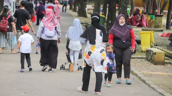 Pengunjung berwisata di Taman Marga Satwa Ragunan, Jakarta Selatan, Senin (28/2/2022). [Suara.com/Alfian Winanto]