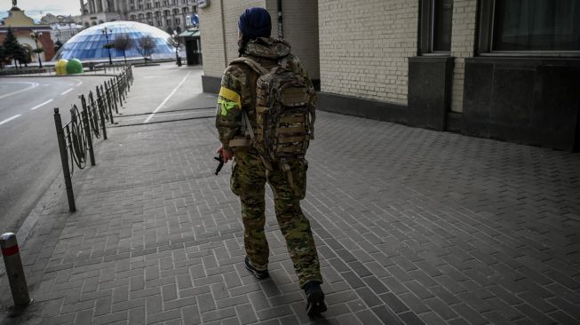 Seorang anggota pasukan Ukraina berpatroli di jalanan di alun-alun Maidan, Kyiv, Ukraina, Minggu (27/2/2022). [Aris Messinis / AFP]