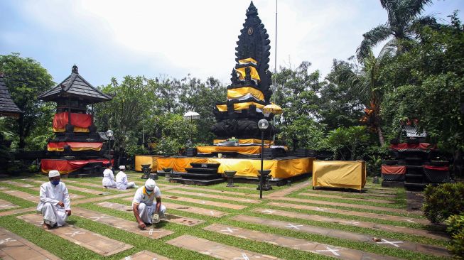 Umat Hindu membuat pedoman jaga jarak untuk pelaksanaan upacara Taur Agung di Pura Parahyangan Jagat Guru, Serpong, Tangerang Selatan, Banten, Senin (28/2/2022). [ANTARA FOTO/Muhammad Iqbal/hp]