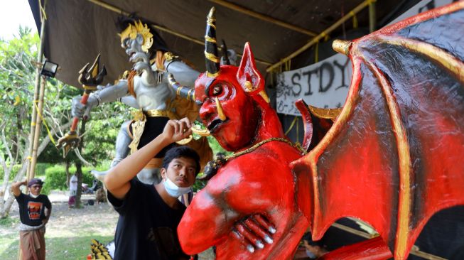 Pemuda menyelesaikan pembuatan ogoh-ogoh di Patoman, Banyuwangi, Jawa Timur, Selasa (1/3/2022).  [ANTARA FOTO/Budi Candra Setya]