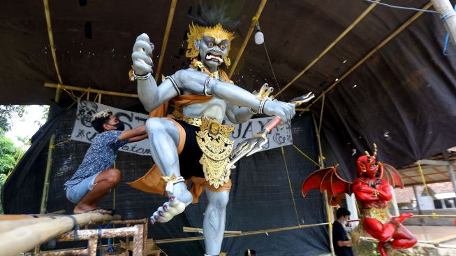 Pemuda menyelesaikan pembuatan ogoh-ogoh di Patoman, Banyuwangi, Jawa Timur, Selasa (1/3/2022).  [ANTARA FOTO/Budi Candra Setya]