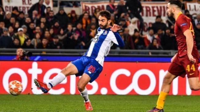 Penyerang Porto Adrian Lopez (kiri) melepaskan tembakan untuk menjebol gawang AS Roma di leg pertama babak 16 besar Liga Champions. [Alberto PIZZOLI / AFP]