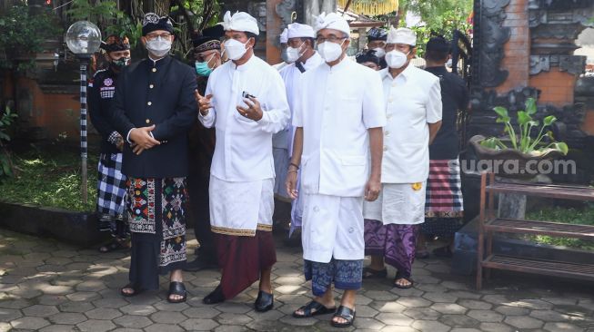 Gubernur DKI Jakarta Anies Baswedan (kanan) saat menghadiri Upacara Tawur Agung Kesanga di Pura Aditya Jaya, Rawamangun, Jakarta Timur, Rabu (2/3/2022). [Suara.com/Alfian Winanto]