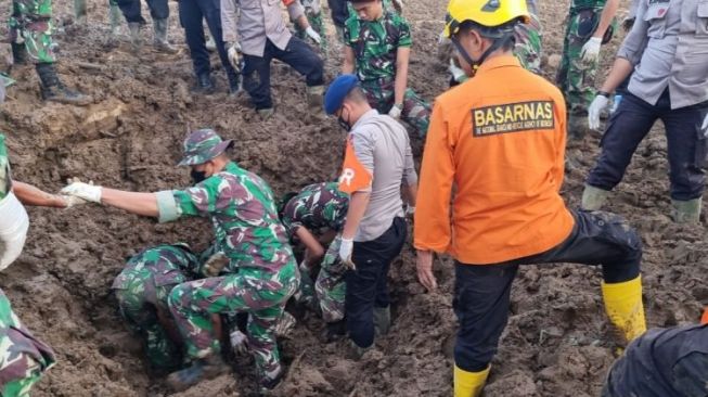 Tim SAR gabungan saat melakukan evakuasi terhadap jasad korban yang tertimbun lumpur longsoran pasca gempa di Pasaman, Rabu (2/3/2022). [Dok.Covesia.com]